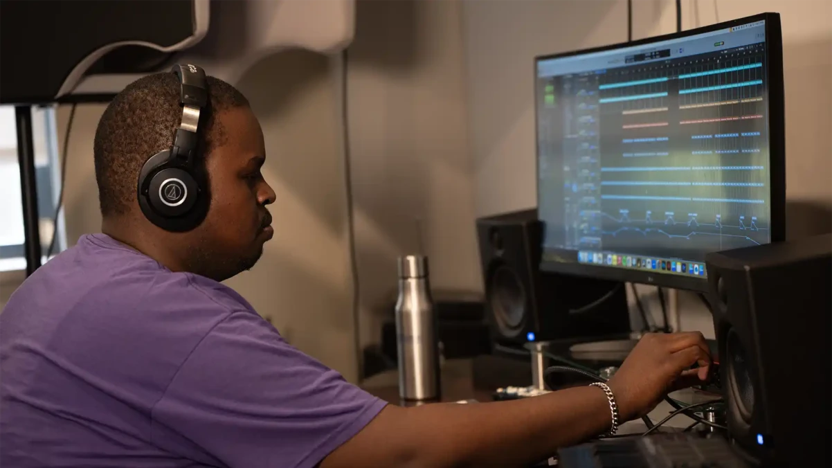 Venture House member recording audio at a computer with headphones on