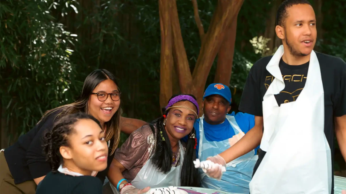 Venture House members hanging out together outside around a patio table